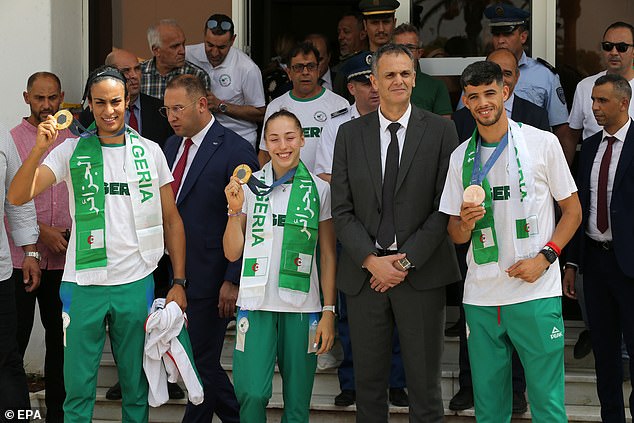 Khelif (front left) poses with his new gold medal as he returns to Algeria with his Olympic teammates